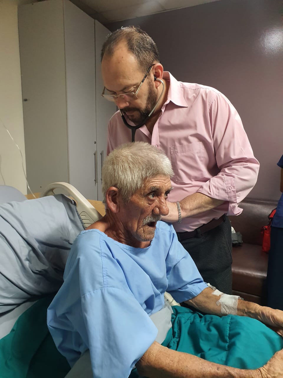 Paciente en recuperación en su habitación de hospital, acompañado por un familiar